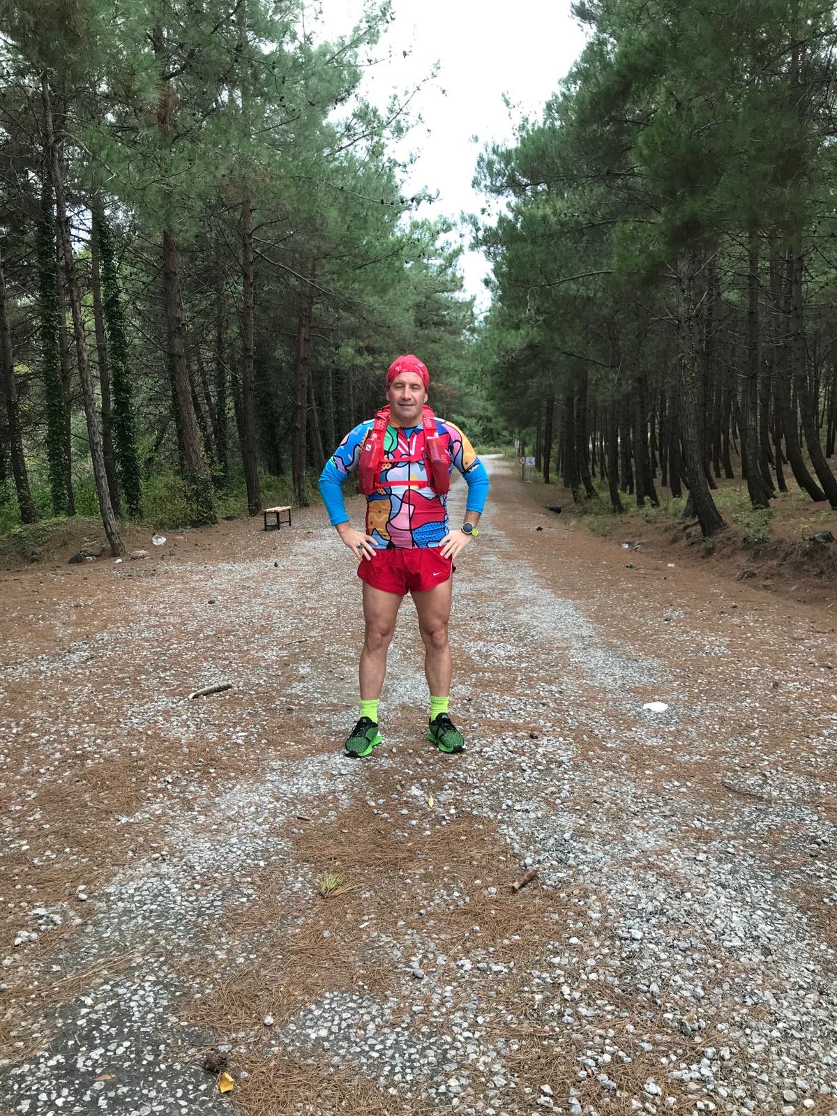 Erden Giritli posing on a forest trail, reflecting his endurance coach and trail running identity