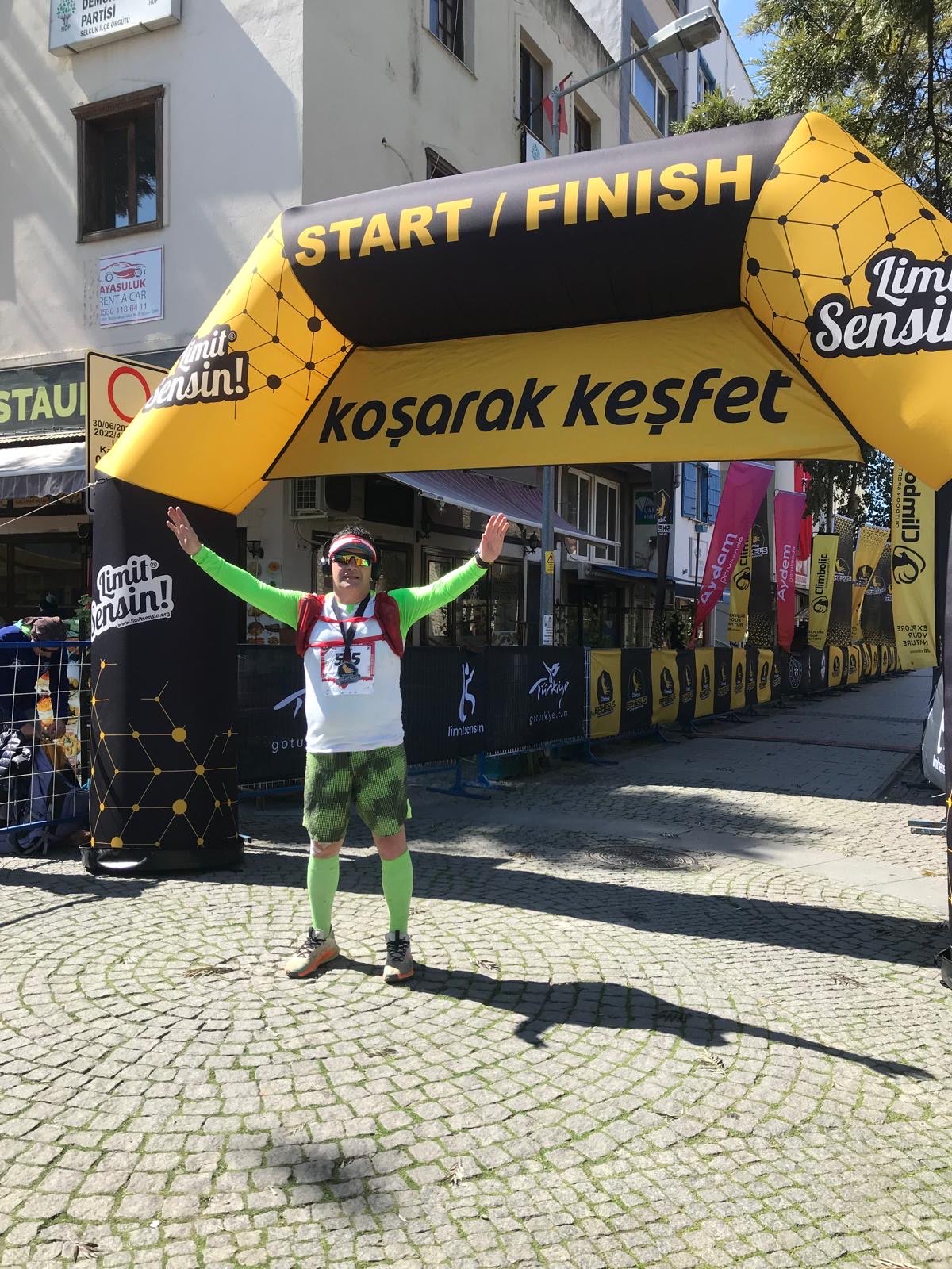 Erden Giritli under a start finish arch, reflecting his running coach and endurance coaching experience