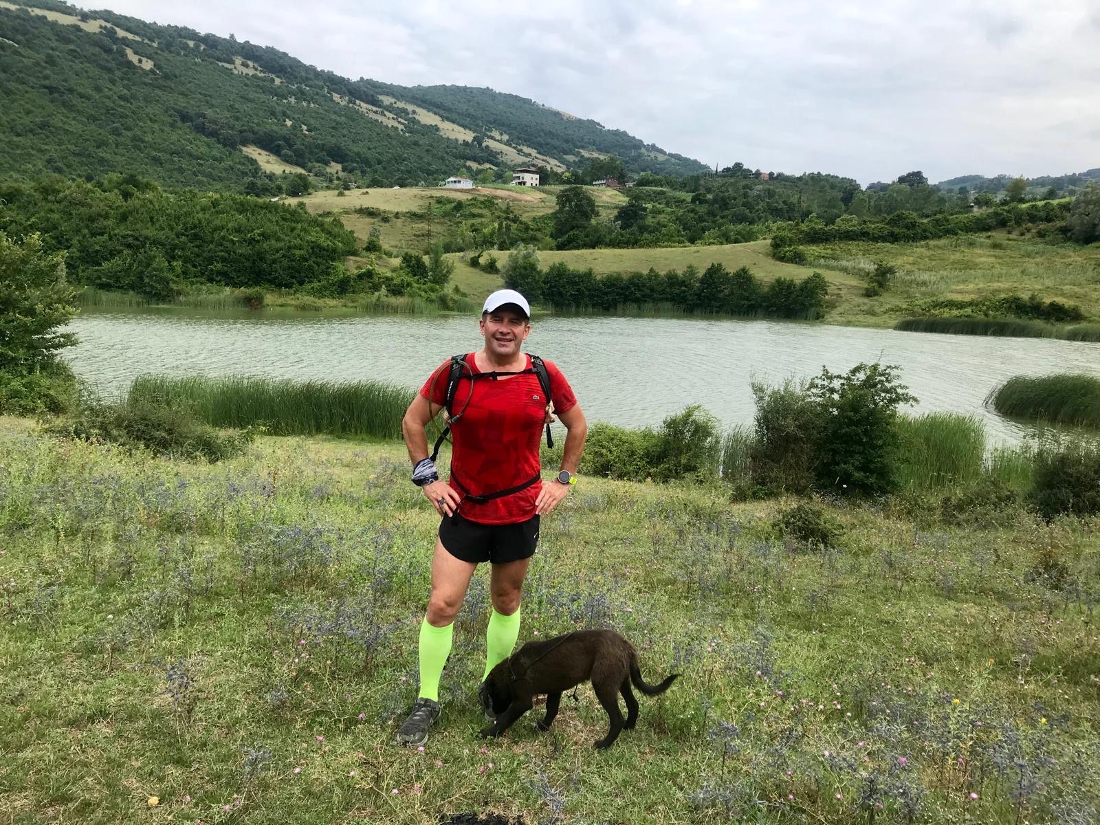 Erden Giritli beside a lake after a trail run, reflecting his healthy lifestyle coach and running coach identity
