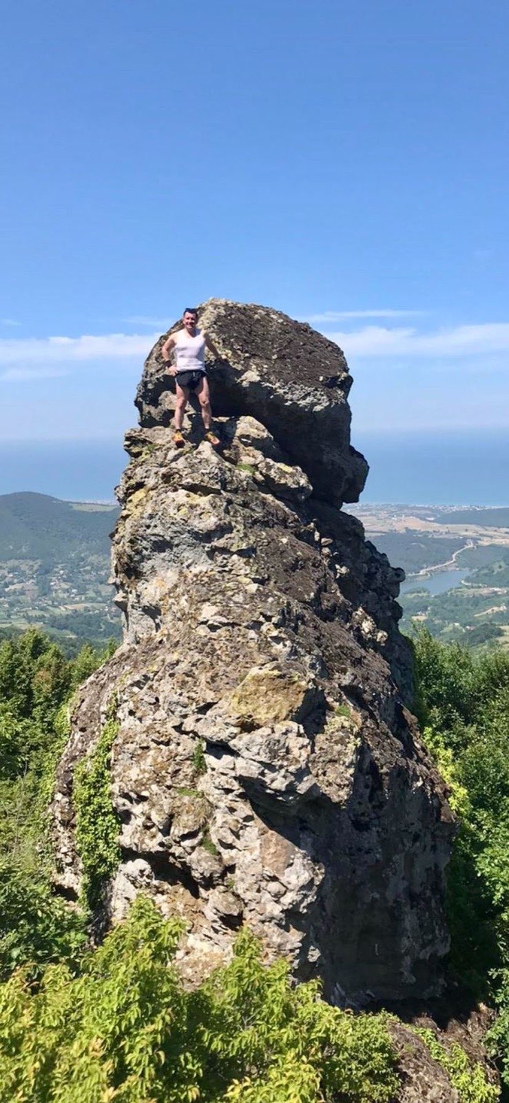 Erden Giritli on a high rocky peak, reflecting his hiking and endurance coach experience