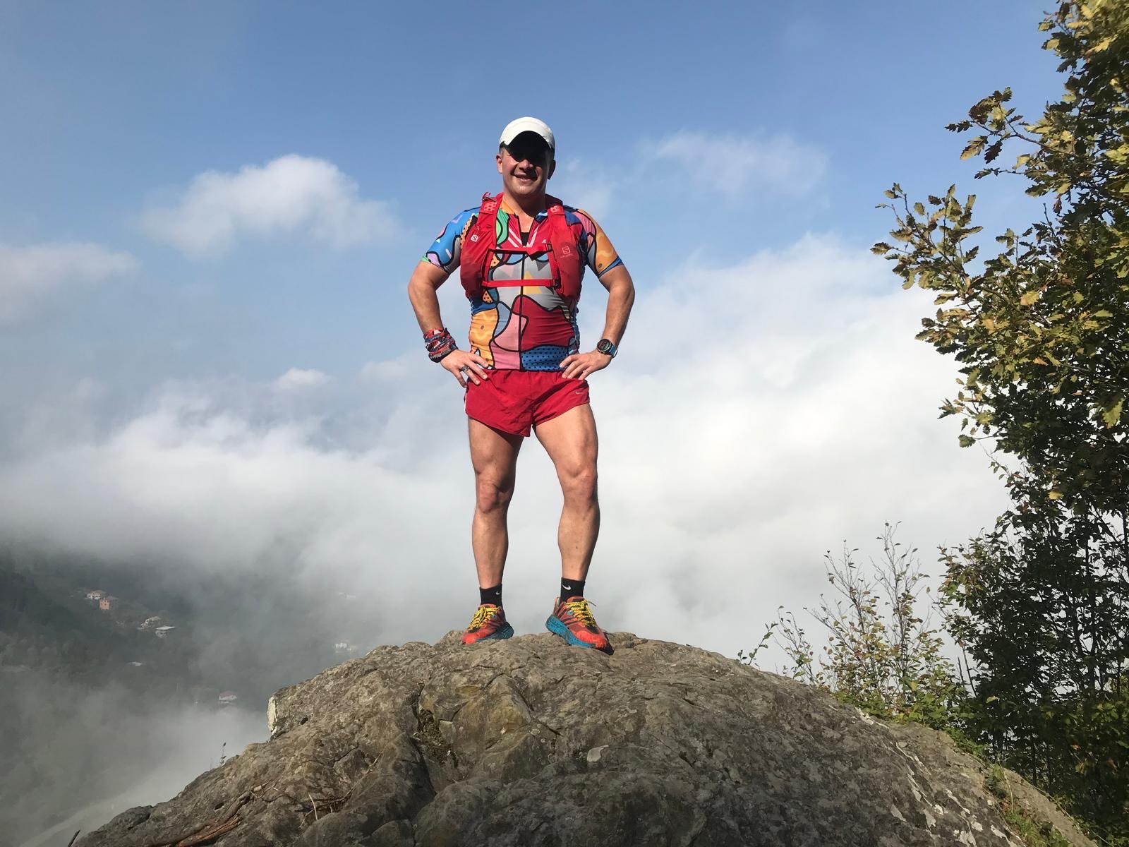 Erden Giritli on a rocky summit after a trail run, reflecting his endurance coach experience