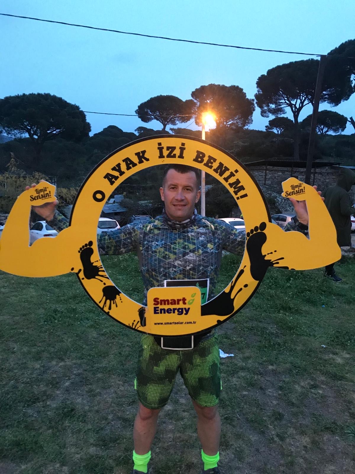 Erden Giritli posing at a Smart Energy ultra trail event, reflecting his work as a personal trainer and endurance coach