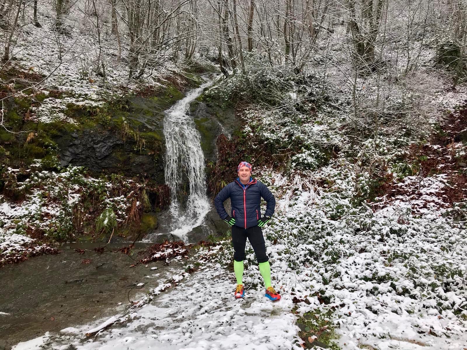 Erden Giritli on a snowy waterfall route, reflecting his healthy lifestyle coach and endurance coach identity