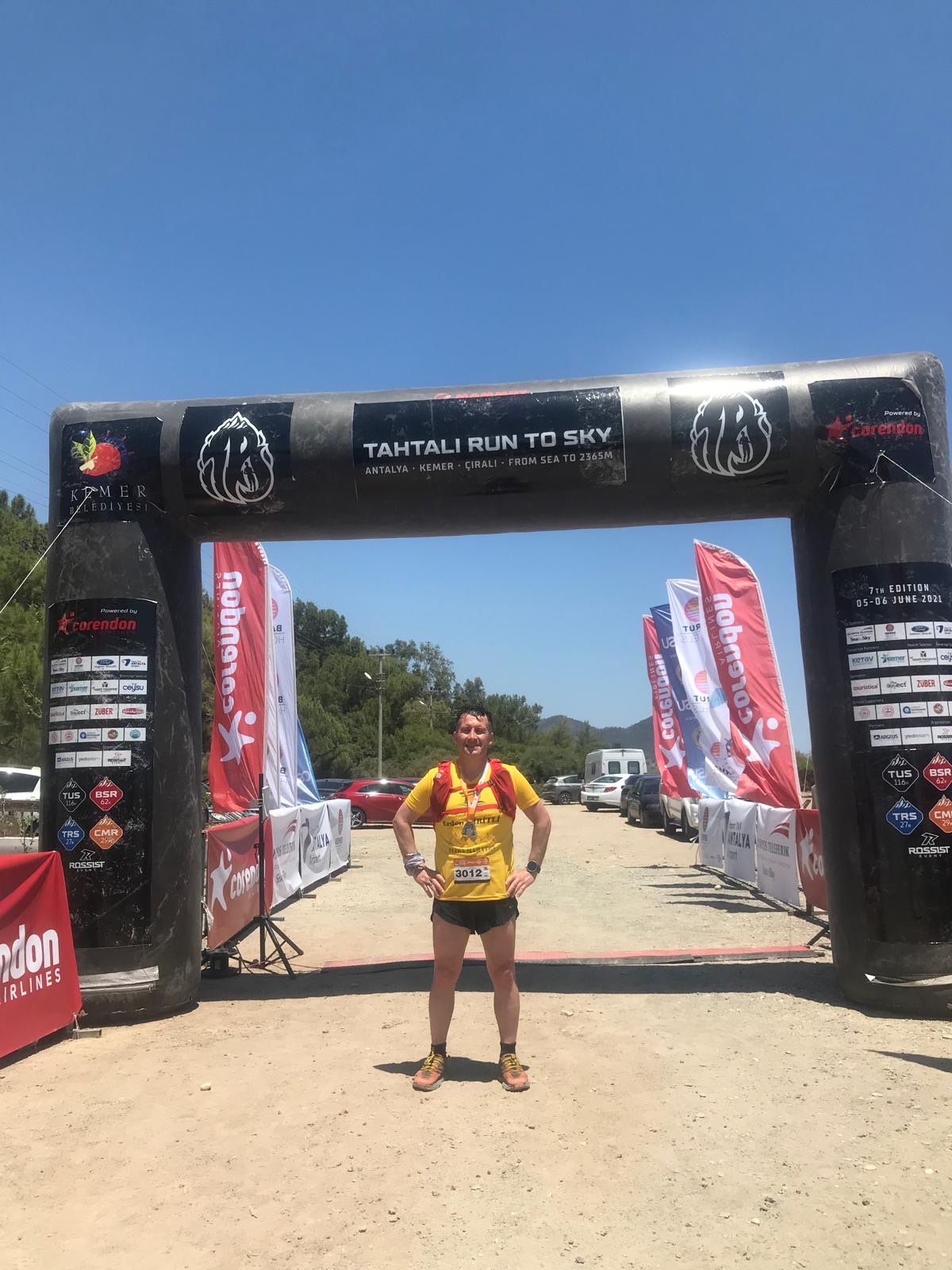 Erden Giritli under the Tahtali Run to Sky start arch, reflecting his running coach experience