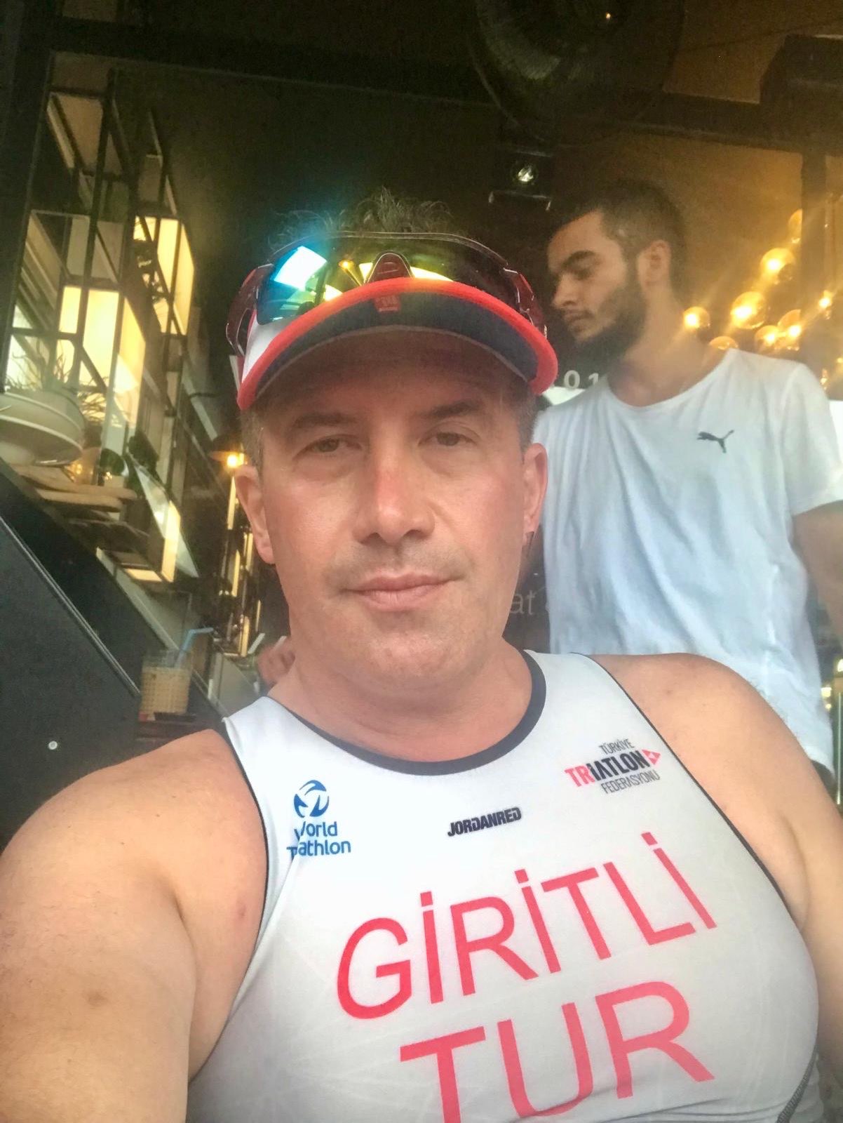 Erden Giritli taking a selfie in a triathlon suit, reflecting his triathlon coach identity
