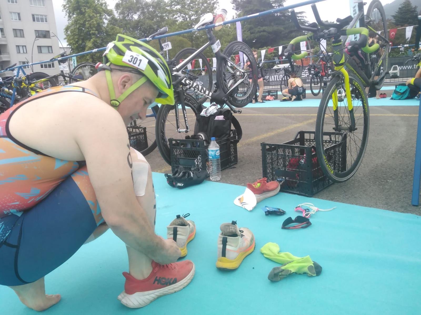 Erden Giritli preparing in a triathlon transition area, reflecting his triathlon coach identity