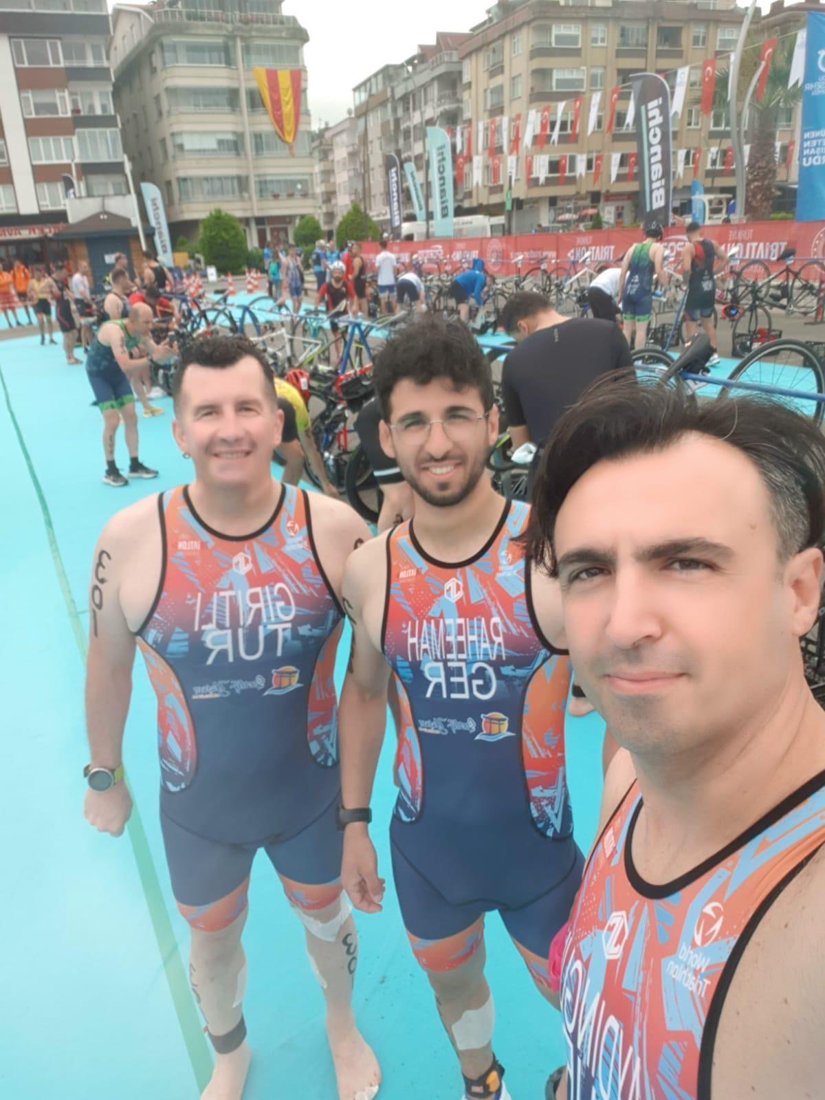 Erden Giritli with teammates in a triathlon transition area, reflecting his triathlon coach experience